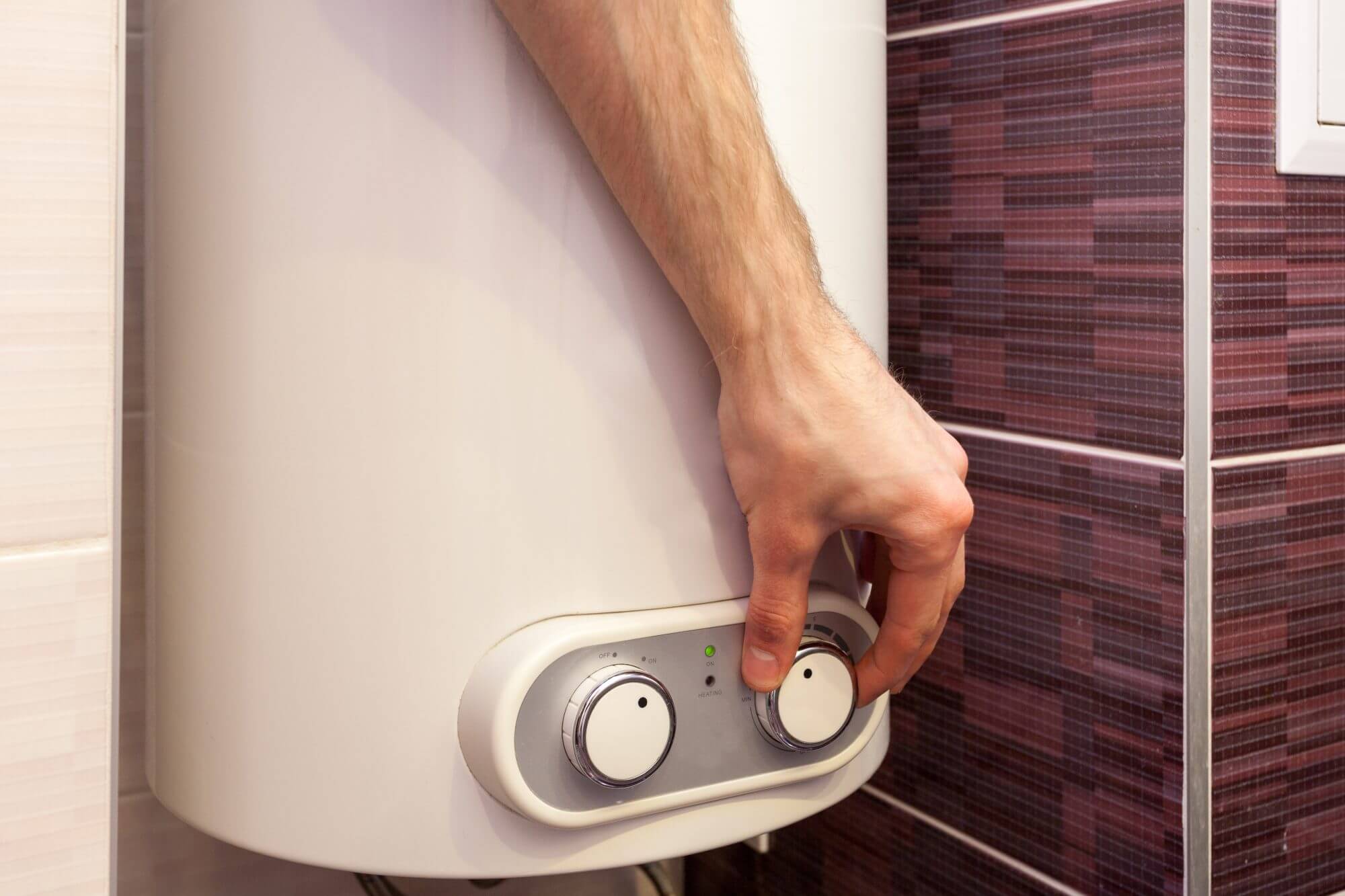 Man hands setting the temperature of water in Electric Boiler