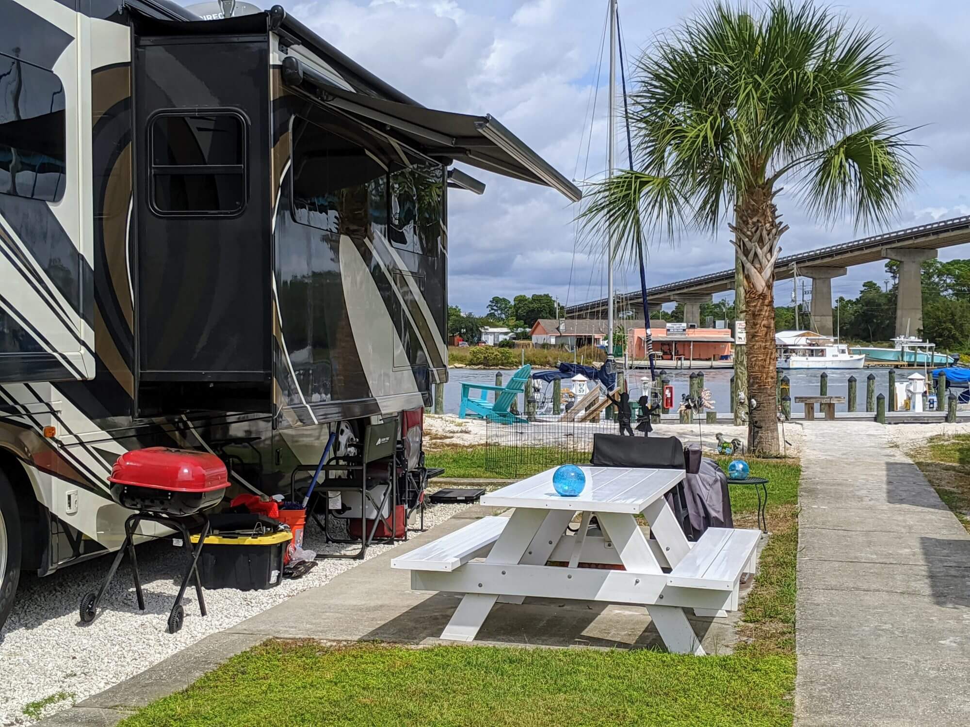 Perdido Key, Florida, October, 15, 2019 - A luxury rv motorhome's camp site is set up for glamping under a palm tree along the waters in Florida