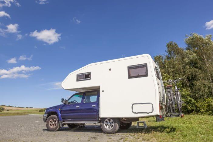 Pickup truck with a camper cabin and bicycles travelling in europe