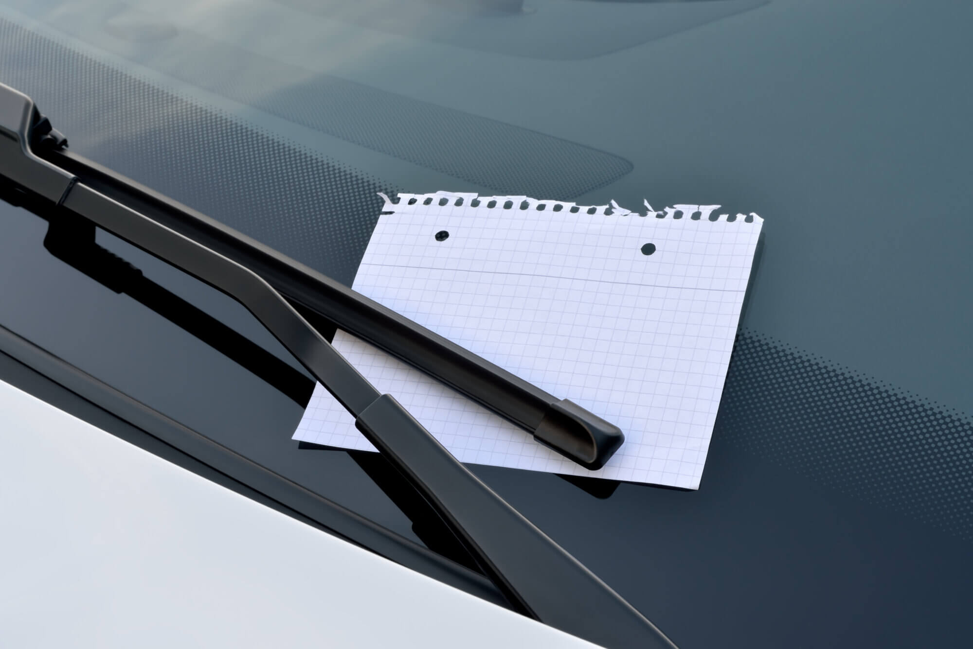 blank sheet of paper under a windshield wiper