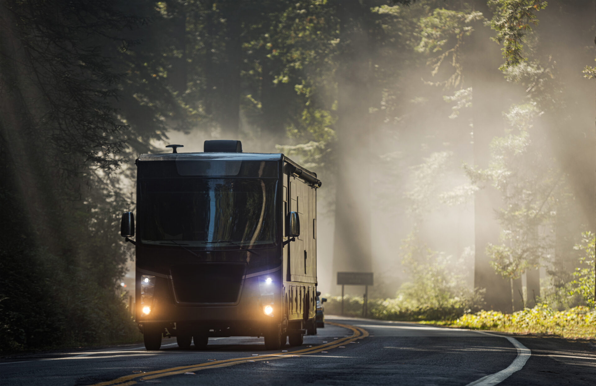 Class A Diesel Pusher Motorhome RV on a Scenic California Highway 101 Covered by Coastal Fog. Motor Coach Road Trip Vacation.