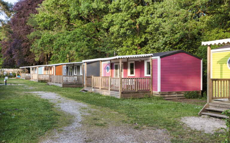 Mobile homes, yellow green orange brown pink with veranda bungalow in a camping for rental