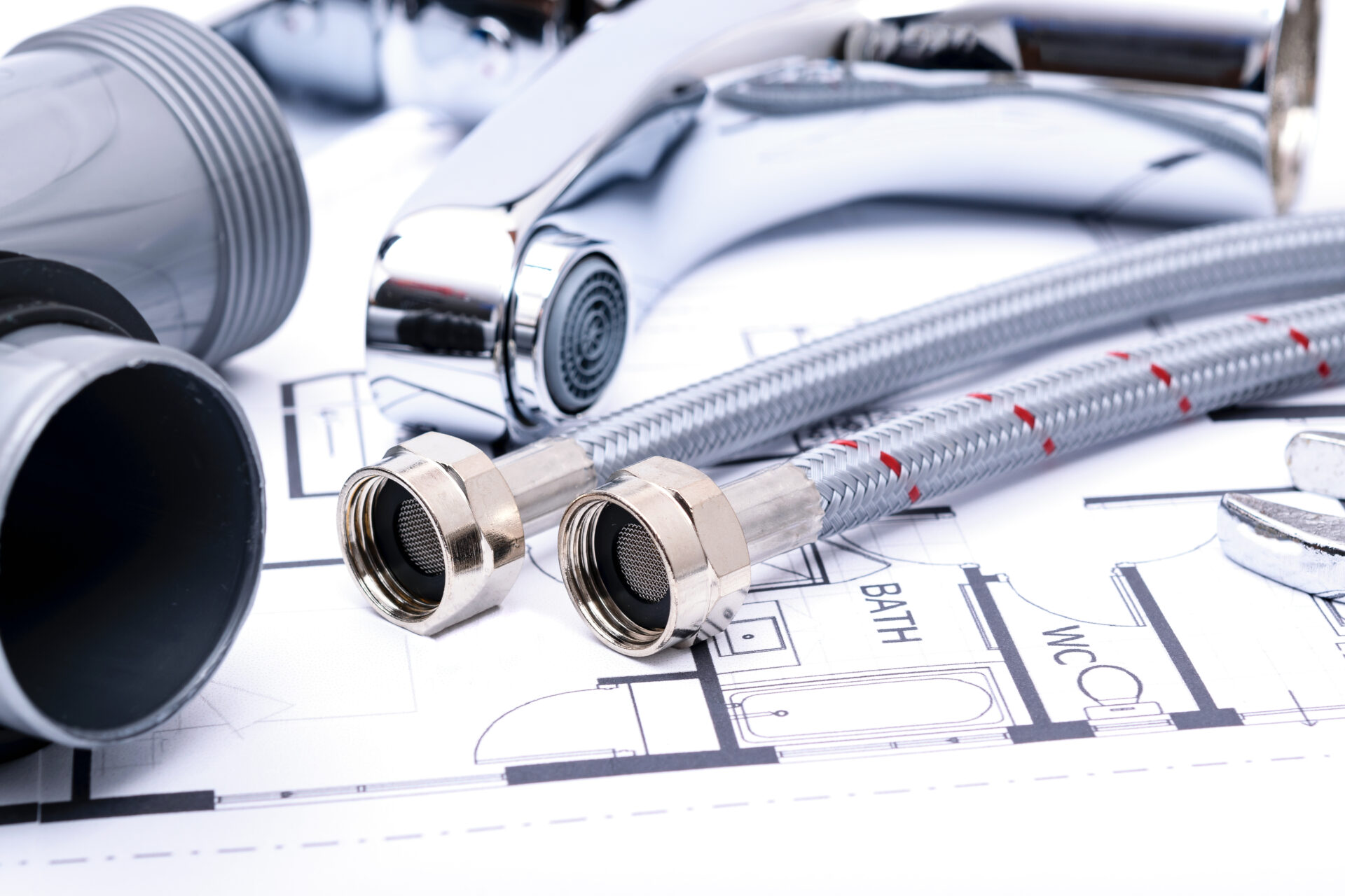 Plumbing tools and faucet on a blueprint project in close-up